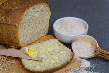 Loaf of bread next to freshly ground flour