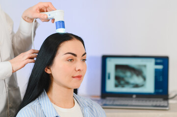 Doctor diagnoses the structure of the hair. Consultation with a trichologist