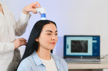 A dermatologist trichologist makes a computer diagnosis of the hair condition of an attractive...