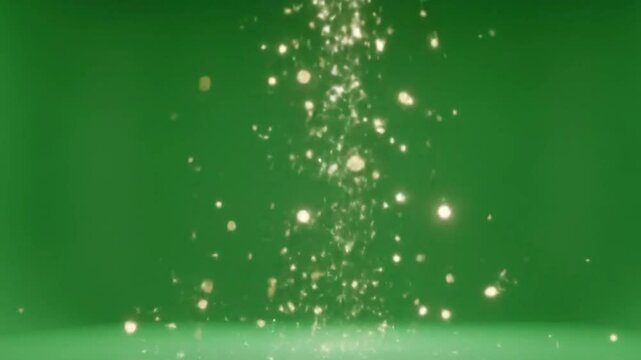 Falling sparkling particles on a green screen background for visual effects and compositing use cases