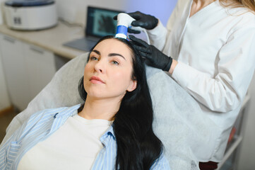 Doctor diagnoses the structure of the hair. Consultation with a trichologist