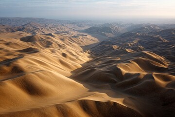 Rolling sand dunes stretch into the distance with a valley cutting through the landscape