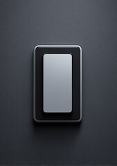 A minimalist, rectangular light switch, silver inner plate, black outer frame, mounted on a dark gray wall