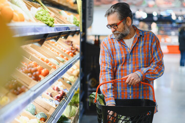 Mature senor in the vegetables section of the supermarket