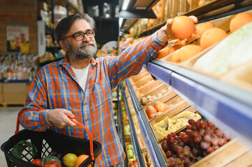 Mature senor in the vegetables section of the supermarket