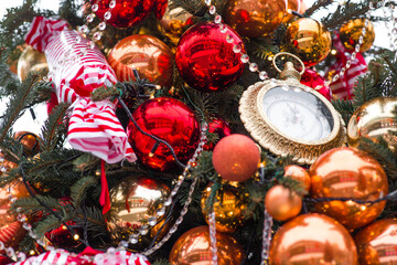 Golden retro clock on a Christmas tree. The clock hands show 12 o'clock. Beautiful background for...