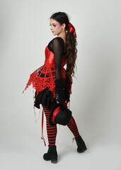 full length portrait burlesque circus performer, female model in halloween jester clown costume...