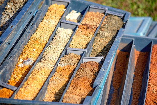 Soil sampling for geologists or civil engineers. Obtaining soil samples in blue plastic box. Selective focus. Research, investigation.	