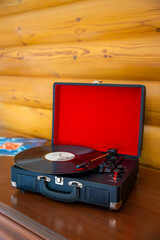 Vintage suitcase-style record player spinning vinyl record. Retro music in motion creating...