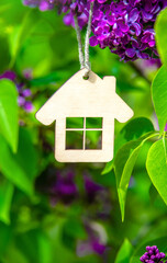 The symbol of the house among the branches of the pink lilac
