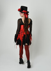 full length portrait burlesque circus performer, female model in halloween jester clown costume...