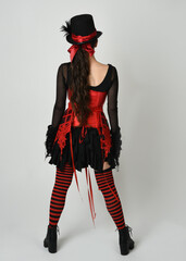 full length portrait burlesque circus performer, female model in halloween jester clown costume...
