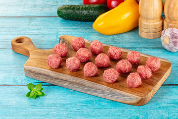 Raw beef meatballs over board