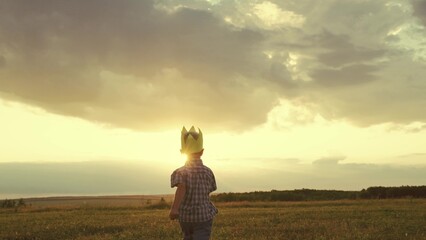 little child boy runs across field with crown head. superhero sun glare light. happy childhood active playful kid. child runs merrily sunset. free adventure kid game. son childhood dream. farming