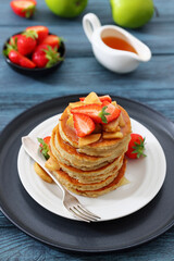 pancakes topped with apple slices and strawberries