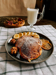 Delicious pancakes served with fresh fruit and a glass of milk in a cozy setting