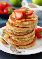 pancakes topped with apple slices and strawberries
