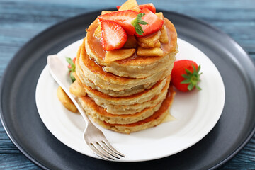 pancakes topped with apple slices and strawberries