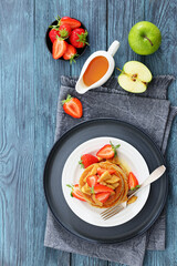 pancakes topped with apple slices and strawberries