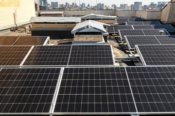 Solar panels installed on the rooftop of a residential building, with a skyline of modern...