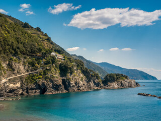 The coast with crystal clear water and green terraces on the slopes. A calm bay of Italian Cinque...
