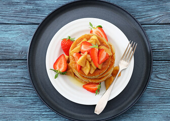pancakes topped with apple slices and strawberries