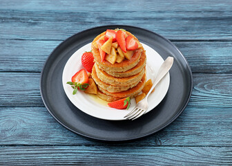 pancakes topped with apple slices and strawberries