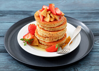 pancakes topped with apple slices and strawberries