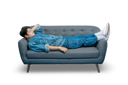 A young man daydreams while lying on a sofa, looking up with a thoughtful and relaxed expression.
