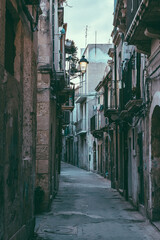 Narrow alleyway with warm street lamp in historic Syracuse, Sicily