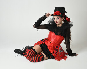 Burlesque circus performer, fantasy female model in halloween jester clown costume with top hat,...
