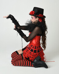Burlesque circus performer, fantasy female model in halloween jester clown costume with top hat,...