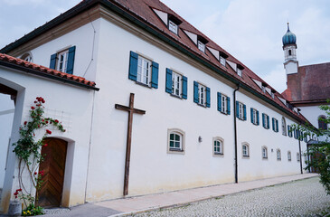 Historic Monastery Building With Wooden Cross and Scenic Architecture