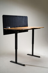 Ergonomic standing desk with a sleek wooden surface and functional privacy divider. Modern office...