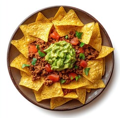Plate of nachos topped with meat, guacamole, and tomato