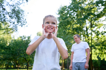 Happy Boy Enjoying Outdoor Fun in a Sunny Park with Family