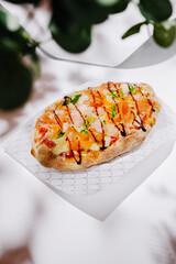 Delicious flatbread topped with colorful vegetables and drizzled sauce