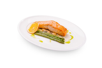 Salmon fillet with asparagus and lemon served on a white plate