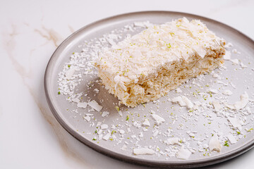 Delicious coconut dessert served on a silver plate with lime zest accents