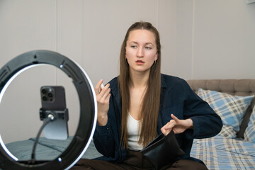 Beauty blogger engaging followers by presenting makeup products during a live stream, utilizing a...