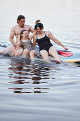 Obraz premium Family Enjoying Quality Time Together on a Paddleboard in a Tranquil Lake