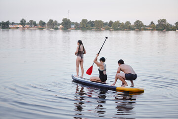 Group of People Enjoying Paddleboarding on a Calm Lake in Nature