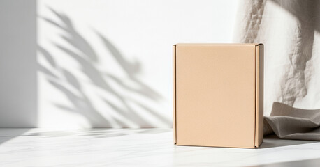Cardboard box on a white surface with shadows and neutral fabric backdrop featured in a soft daylight setup for minimal and elegant product display
