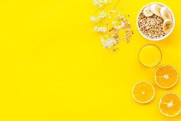 food for healthy breakfast with granola and fresh orange juice on bright yellow background top view mock up
