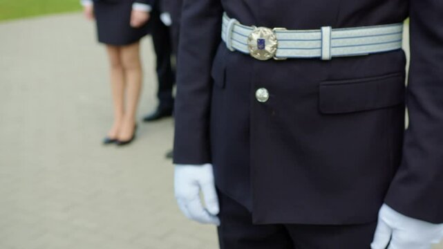 Close-up of attaching a lieutenant shoulder epaulette to a Ukrainian police officer in ceremonial uniform