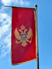The flag of Montenegro at the border with blue sky