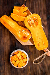 Pumpkin - slices on cutting board - on wooden background top-down