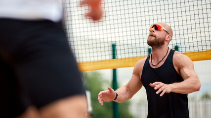 Man Playing Beach Volleyball Wearing Sunglasses During Match Outdoors