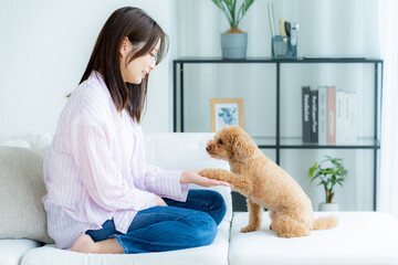部屋でペットとくつろぐ若い女性