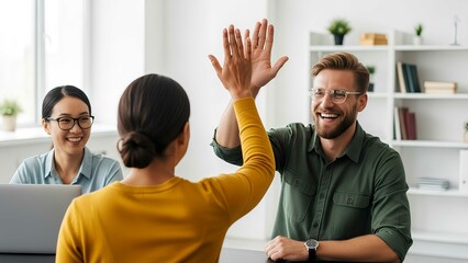 Business team celebrating success at work with high fives and smiles in a bright modern office. Happy coworkers achieving goals together.